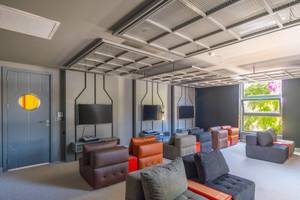 Loungebereich des Sherwood Exclusive Kemer Hotels mit verschiedenen Sofas, Fernsehgeräten und Fenstern.