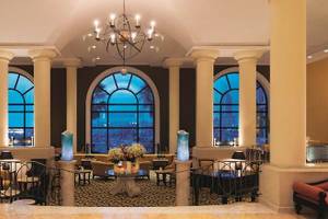 Corinthia St George's Bay Hotel-Lobby mit großen Fenstern und Kronleuchter