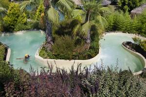 Wasserrutsche im Club Grand Side Hotel, umgeben von Pflanzen und Palmen.