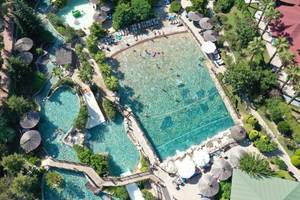 Luftaufnahme des Schwimmbads im Club Grand Side Hotel mit mehreren Schwimmern und Sonnenschirmen
