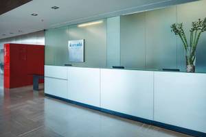 Empfangsbereich des Barcelo Valencia Hotels mit moderner Einrichtung und Barcelo Schild.