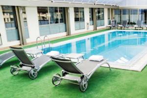 Außenpool im SH Valencia Palace Hotel mit Liegestühlen und Sonnenschirmen