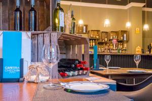 Ein Restaurantbereich des DWO Valencia Hotels mit einer Tischanordnung, Flaschen und Gläsern.