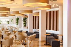 Innenbereich des RH Bayren & Spa Hotels mit runden Deckenleuchten und braunen vertikalen Streifen an der Wand.