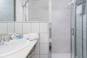 Badezimmer im Hotel Principal Afilliated by RH mit Dusche, Waschbecken und Handtüchern.