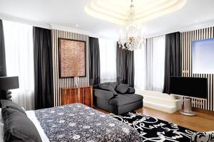 Schlafzimmer im Westin Valencia Hotel mit einem Bett, Sofa, Fernseher, Lampen und Kunstwerk.