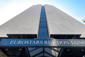 Fassade des Eurostars Rey Don Jaime Hotels mit Logo und blauen Glasfenstern.