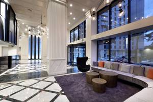 Lobby des Exe Rey Don Jaime Hotels mit modernem Design, weißen Säulen und gemustertem Boden.