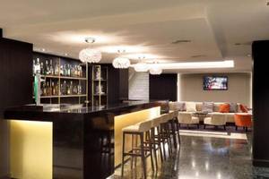 Bar im Hotel Exe Rey Don Jaime mit goldenen Akzenten und modernen Möbeln.