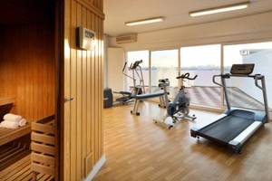 Fitnesscenter im Exe Rey Don Jaime Hotel mit Laufband, Spinnrad und anderen Geräten.