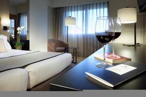Hotelzimmer im Exe Rey Don Jaime mit Bett, Weinglas, Buch und Deko