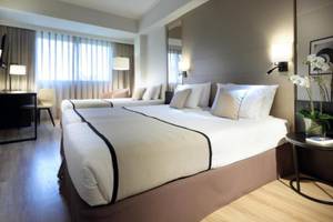 Doppelzimmer im Exe Rey Don Jaime Hotel mit zwei Betten, Dekor und Möbeln.