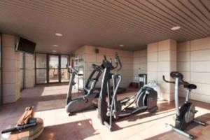 Fitnessbereich im Valencia Center Hotel mit Laufbändern, Fahrradtrainern und Hanteln.