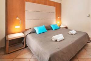 Hotelzimmer im Lindos Royal Resort mit blauen Kissen und grauer Bettwäsche.