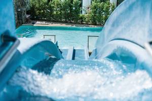 Wasserrutsche im Lindos Royal Resort mit klarem Wasser und blauem Pfad.