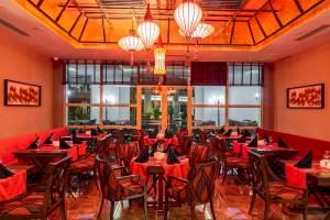 Innenansicht des Restaurants im Sunis Efes Royal Palace Resort & Spa mit roten Tischen und Stühlen.