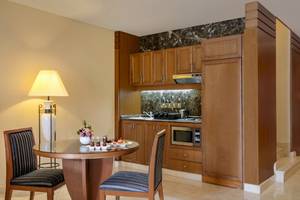 Küche im Al Ain Rotana Hotel mit Tisch, Stühlen und Mikrowelle