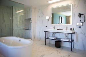 Ein Badezimmer im Riu Plaza Espana Hotel mit Badewanne, Waschbecken und Spiegel.
