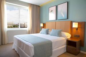 Hotelzimmer mit Bett, Kissen, Fenster und Nachttisch im Riu Plaza Espana