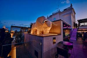 Terrasse des Riu Plaza Espana mit einer großen Stier-Skulptur bei Nacht