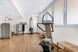 Fitnessbereich im Hotel ALUA Gran Camp de Mar mit Laufband, Gewichtsbank und Rudergerät.