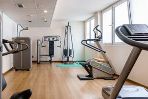 Fitnessraum im ALUA Gran Camp de Mar mit verschiedenen Trainingsgeräten und Yoga-Matten.