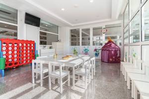 Kinderspielzimmer im ALUA Gran Camp de Mar Hotel mit Tisch, Stühlen und Spielgeräten.