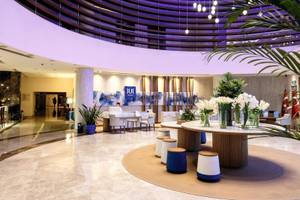 Lobby des TUI BLUE Side Hotels mit moderner Inneneinrichtung, Empfangstresen und Tisch mit Blumen.