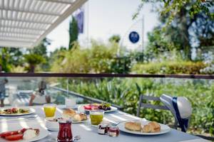 Frühstückstisch auf der Terrasse des TUI BLUE Side Hotels mit verschiedenen Speisen und Getränken.