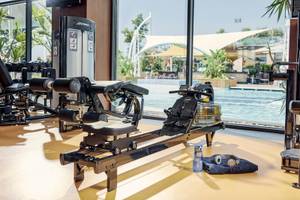 Fitnessstudio im Hotel TUI BLUE Side mit Blick auf den Pool und Trainingsgeräten.