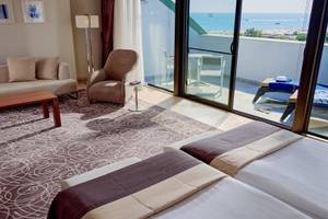 Suite Zimmer mit Meerblick im TUI BLUE Side Hotel, mit Möbeln und Balkon.