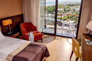 Zimmer im TUI BLUE Side Hotel mit Blick auf einen Balkon und Meer.