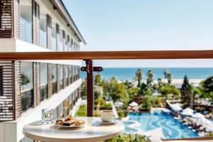 Blick vom Balkon des TUI BLUE Side Hotels auf das Meer mit einem Frühstückstablett auf dem Tisch.