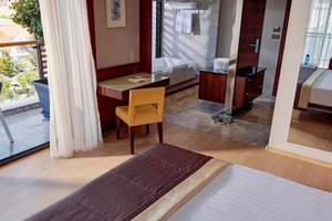 Hotelzimmer im TUI BLUE Side mit Schreibtisch, Sessel, Bad und Balkon.