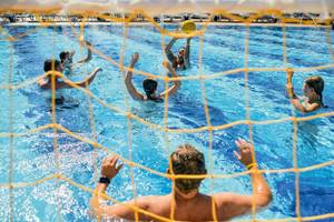 Wasserballspiel im Swimmingpool des Magic Life Jacaranda Hotels mit Spielern und einem Trainer.