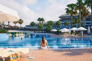 Ein Schwimmbadbereich des Magic Life Jacaranda Hotels mit einer Frau am Rand des Beckens.