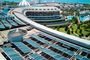 Luftaufnahme des Magic Life Jacaranda Hotels mit Solarpaneelen, Gebäuden und Swimmingpools am Meer.