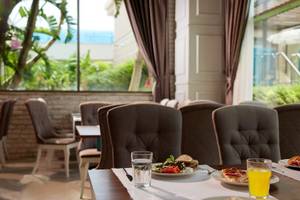 Frühstückstisch im Magic Life Jacaranda Hotel mit Speisen und Getränken.