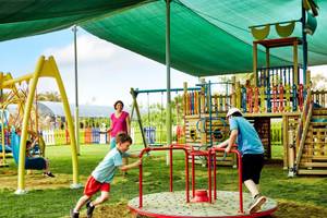 Kinder spielen auf einem Spielplatz im Magic Life Jacaranda Hotel.