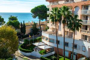 Canyamel Classic Hotel mit Blick auf das Meer und Palmenbäumen.