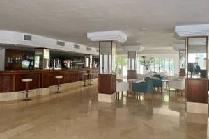 Innenansicht der Bar im Canyamel Classic Hotel mit Theke, Stühlen und Tischen.