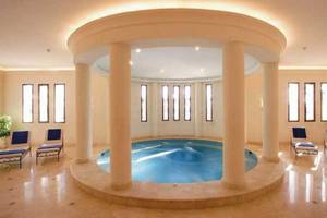 Innenpool im Jaz Belvedere Resort mit runden Säulen und Lounge-Liegen.
