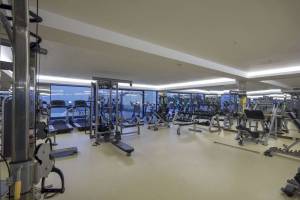 Fitnesscenter im Hotel Granada Luxury Okurcalar mit vielen Trainingsgeräten und großen Fenstern