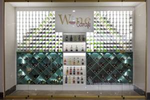 Weinkeller im Granada Luxury Okurcalar Hotel mit grün beleuchteten Flaschen und 'Wine Carafe' Schild.