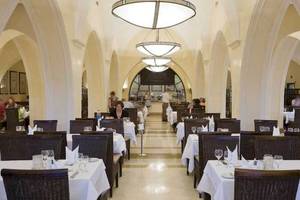 Innenansicht des Jaz Belvedere Resort Restaurants mit gedeckten Tischen und eleganten Kronleuchtern.