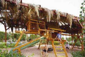 Kinderspielplatz im Jaz Belvedere Resort mit Rutsche, Schaukeln und Sandkasten.