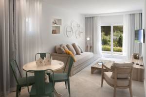 Hotel Paraiso de los Pinos Wohnzimmer mit Sofa, Tisch und Fernseher.