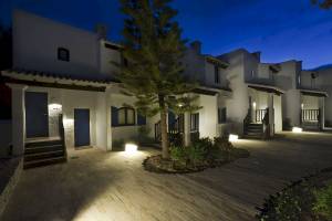 Nachtansicht des Paraiso de los Pinos Hotels mit beleuchteten Eingängen und Gehwegen.