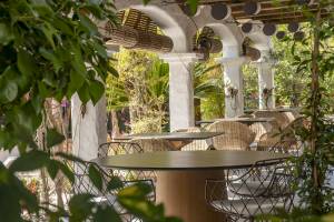 Terrasse des Paraiso de los Pinos Hotels mit Tischen und Stühlen unter Überdachungen