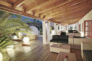 Loungebereich im Tahiti Hotel mit Holzboden, weißen Kissen und Laternen.